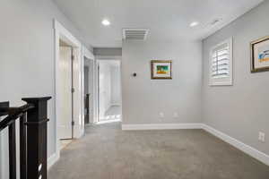 Hall with carpet, recessed lighting, a textured ceiling, and an upstairs landing