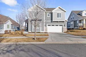 Craftsman inspired home with board and batten siding, concrete driveway, and an attached garage
