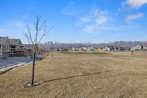 View of property's community with a mountain view, a residential view, and a yard