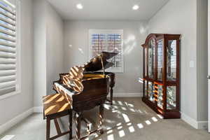 Living area featuring light carpet, recessed lighting, and radiator heating unit