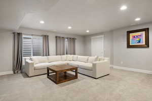 Carpeted living room with baseboards and recessed lighting