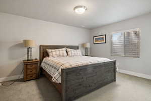 Bedroom featuring light carpet and a textured ceiling