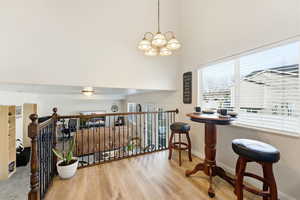 Dining space with wood finished floors, a chandelier, and a towering ceiling