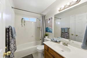 Bathroom featuring shower / tub combo with curtain, vanity, and light tile patterned flooring