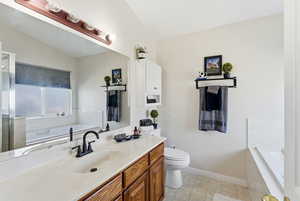 Full bath with a bath, vanity, lofted ceiling, and a shower with shower door