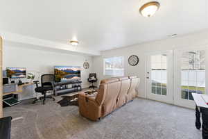 Carpeted living area featuring baseboards