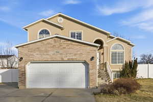 Mediterranean / spanish home featuring driveway, stucco siding, brick siding, and an attached garage