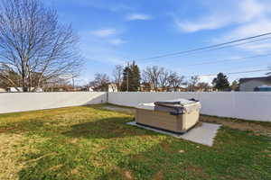 Fenced backyard with a hot tub