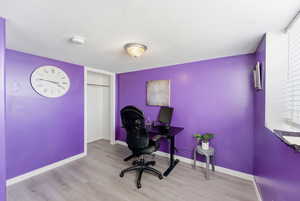 Office featuring wood finished floors and a textured ceiling