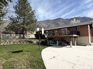 Rear view of property featuring brick siding and a deck with mountain view