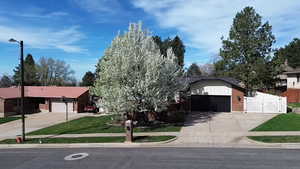 Ranch-style home with brick siding, driveway, a gate, and a garage