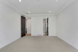 Unfurnished bedroom with light colored carpet and recessed lighting