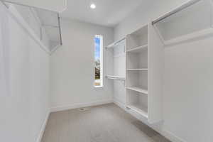 Walk in closet with light carpet