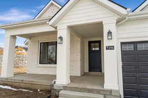 Property entrance featuring brick siding and a porch