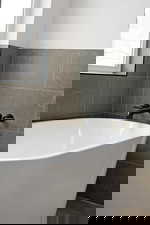 Full bath with tile walls and a freestanding tub