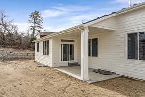 View of home's exterior with a patio area and a shingled roof