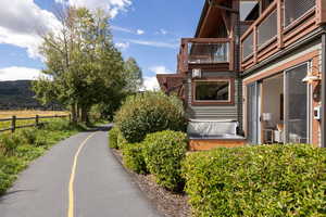 View of side of property with a hot tub and a balcony