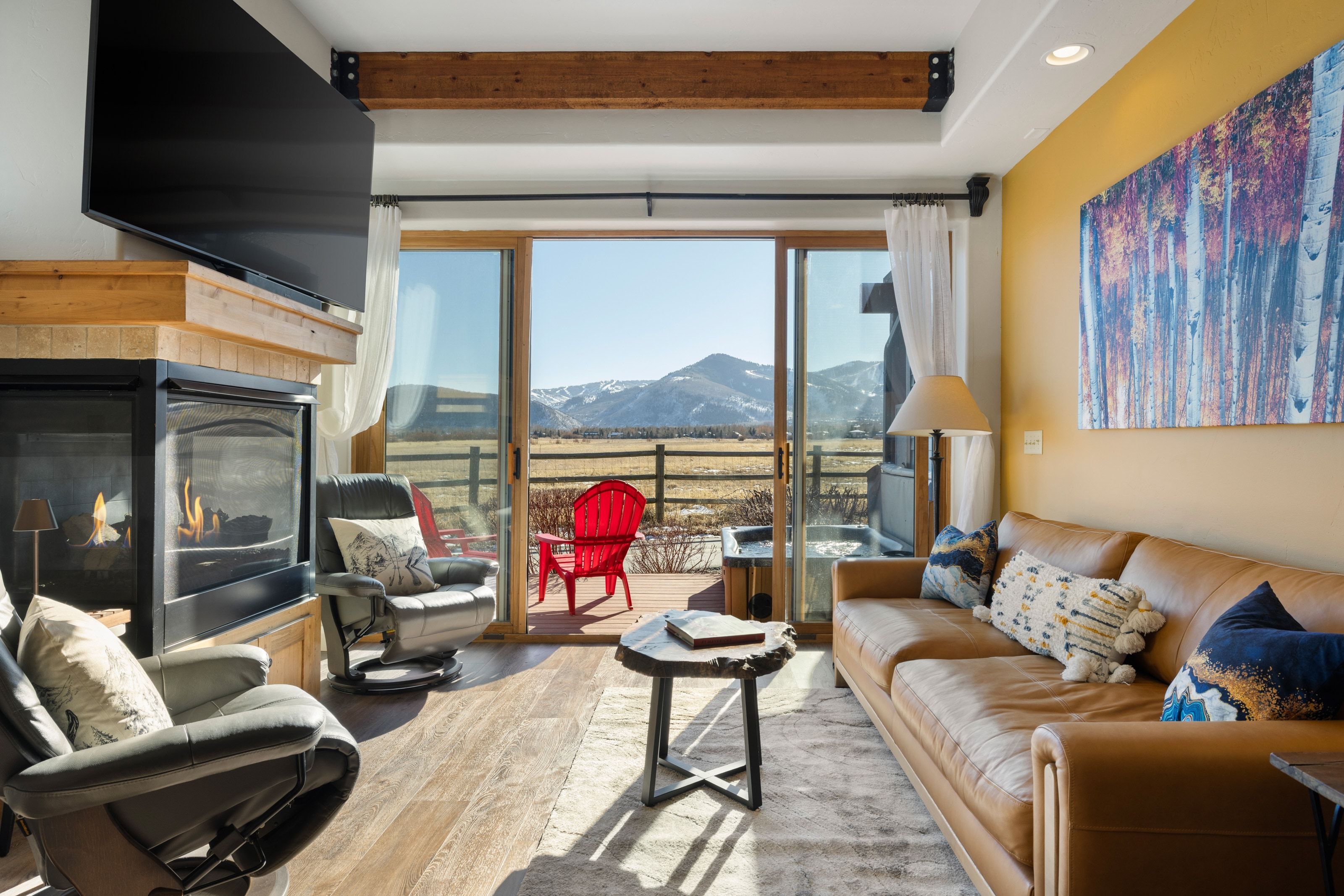 Living area with wood finished floors and a glass covered fireplace