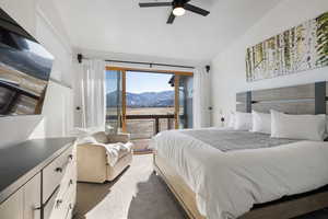 Bedroom with a mountain view, access to exterior, dark carpet, a ceiling fan, and lofted ceiling