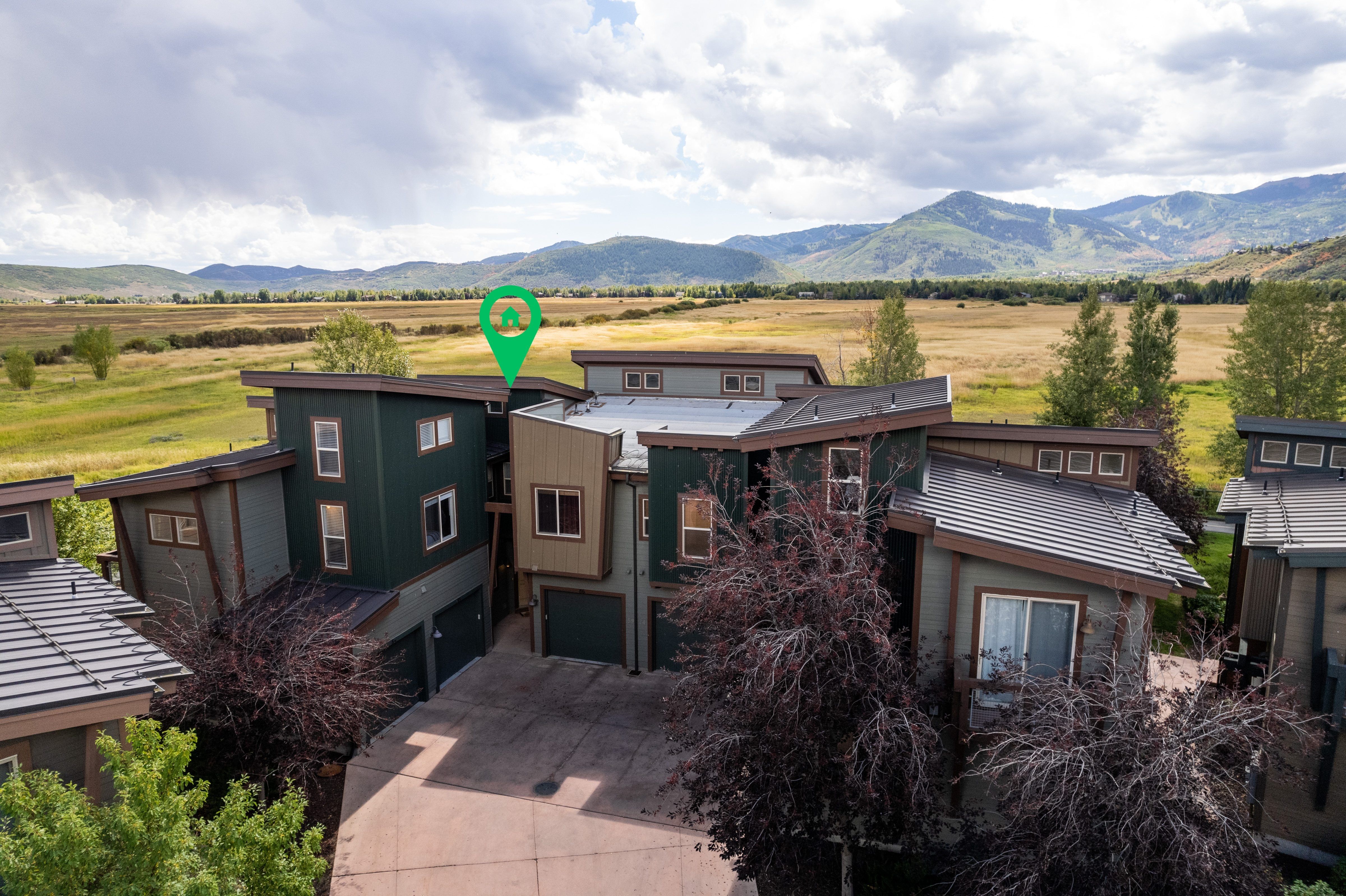 Modern home with a garage, driveway, a mountain view, and a view of rural / pastoral area
