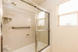 Bathroom with bath / shower combo with glass door