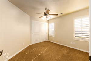 Unfurnished bedroom with carpet flooring, a textured ceiling, a ceiling fan, and a closet