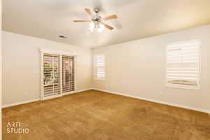 Carpeted spare room with a ceiling fan and baseboards