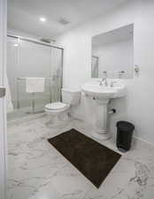 Full bath featuring a shower stall and light marble finish flooring
