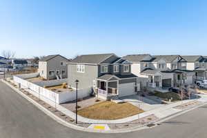Traditional home featuring a residential view, concrete driveway, covered porch, and an attached garage