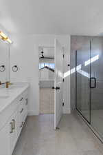 Full bathroom with a shower stall, double vanity, light carpet, and light tile patterned flooring