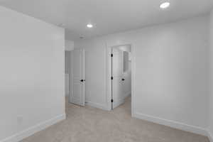 Empty room featuring light carpet and recessed lighting