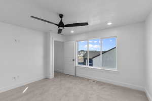 Unfurnished bedroom with light colored carpet, ceiling fan, and recessed lighting