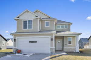 Craftsman-style home featuring roof with shingles, concrete driveway, a garage, stone siding, and covered porch
