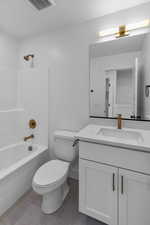 Bathroom with shower / bathtub combination, vanity, and dark tile patterned flooring