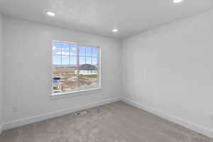 Empty room featuring carpet floors, recessed lighting, and a mountain view