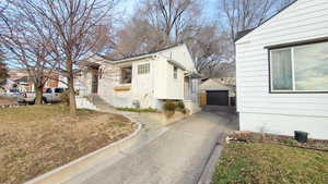 View of home's exterior featuring a detached garage, and driveway