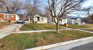 Bungalow-style home featuring a front lawn, a residential view, and driveway