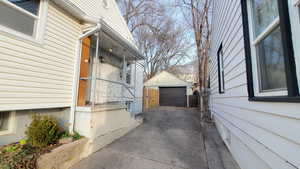 View of side of home with a detached garage, and driveway