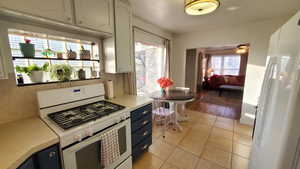 Kitchen with white appliances, light countertops, light tile floors, and an old timey light