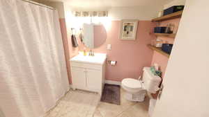 Bathroom featuring vanity, a shower with shower curtain, and light tile floors
