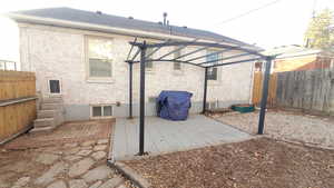 Fenced backyard with a patio, a pergola, and area for grilling