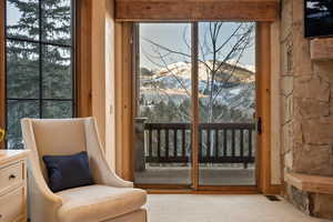 Doorway to outside with a mountain view, carpet, and healthy amount of natural light