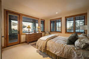 Bedroom with access to exterior, light carpet, and recessed lighting