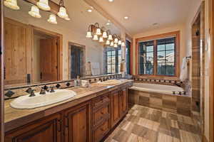 Full bath featuring a garden tub, double vanity, recessed lighting, and a shower stall