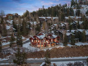 Snowy aerial view featuring view of wooded area