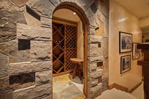 Wine cellar featuring arched walkways and stone floors