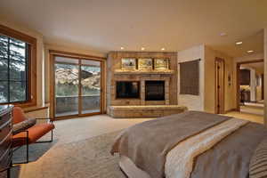 Bedroom featuring light colored carpet, access to outside, a fireplace, and recessed lighting