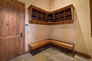 Mudroom featuring baseboards and a textured wall