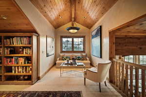 Living area with carpet and a wooden ceiling with exposed beams