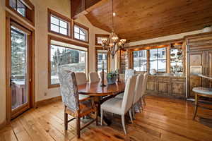 Dining room featuring a high wooden beamed ceiling, suspended lighting, and light wood-type flooring